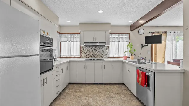 a kitchen with stainless steel appliances granite countertop a sink and a refrigerator