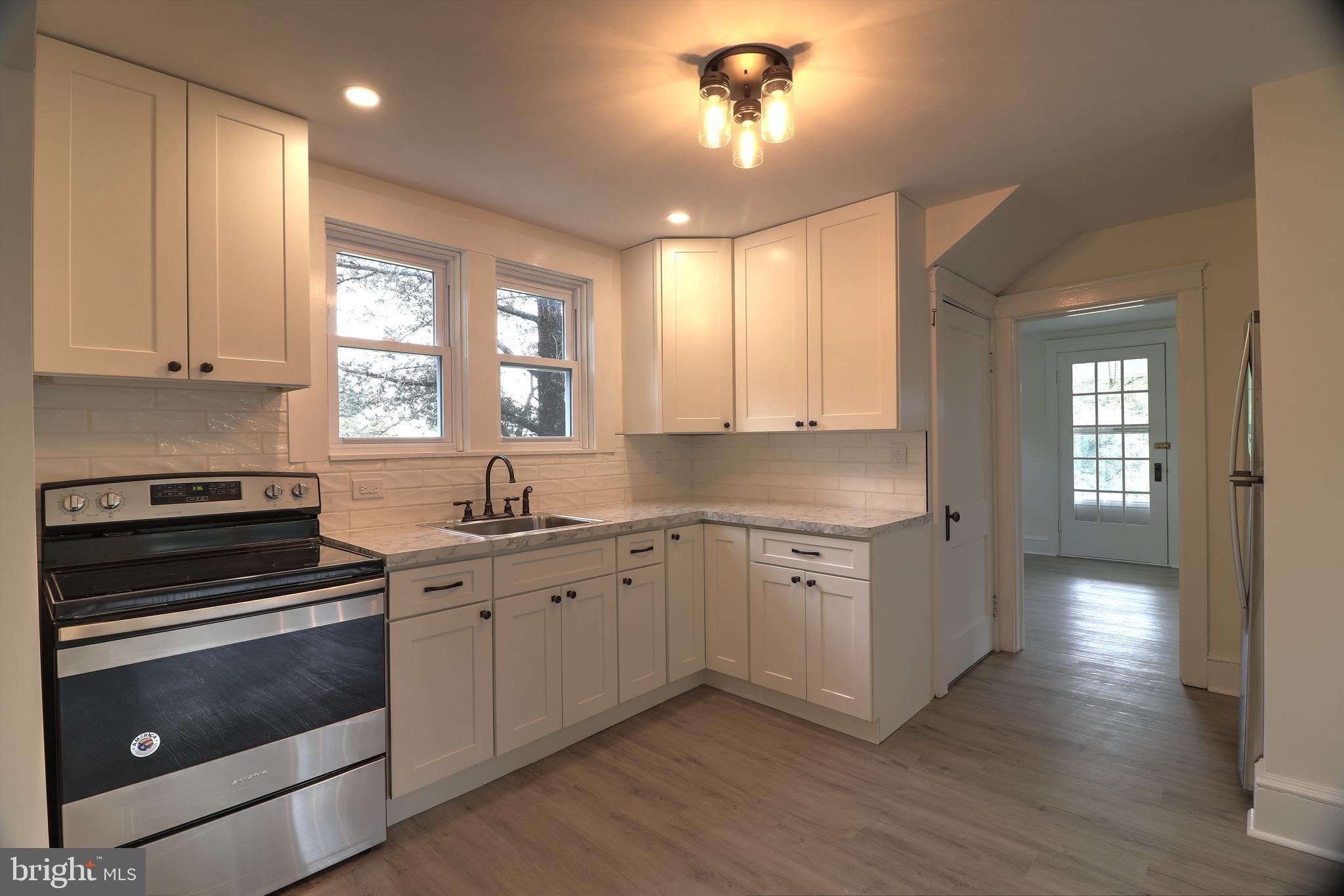 678 Rockville Road Spring Grove, PA 17362 - Photo 2 of 32 a kitchen with granite countertop a stove cabinets and wooden floor