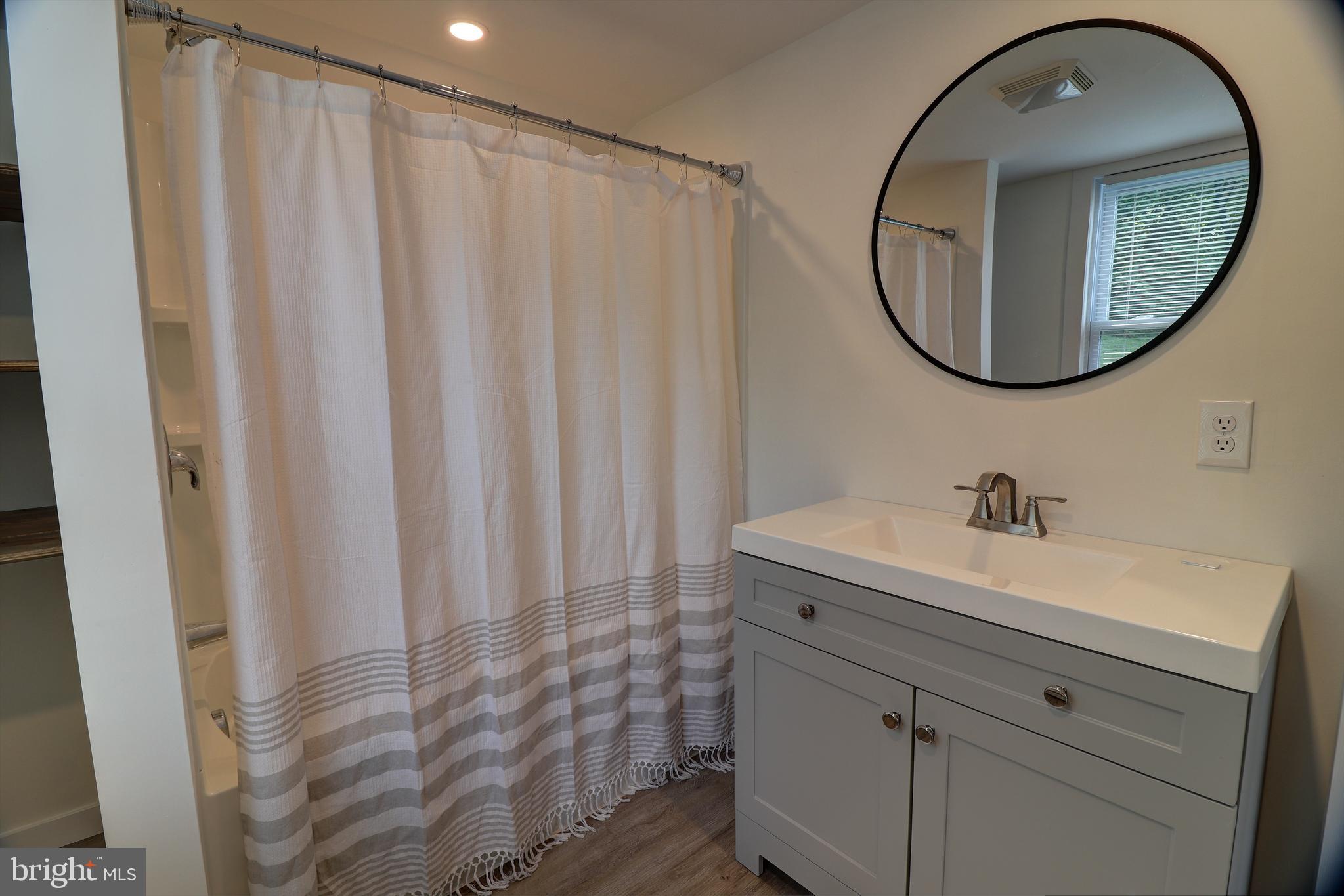 678 Rockville Road Spring Grove, PA 17362 - Photo 13 of 32 a bathroom with a sink a mirror and a shower curtain