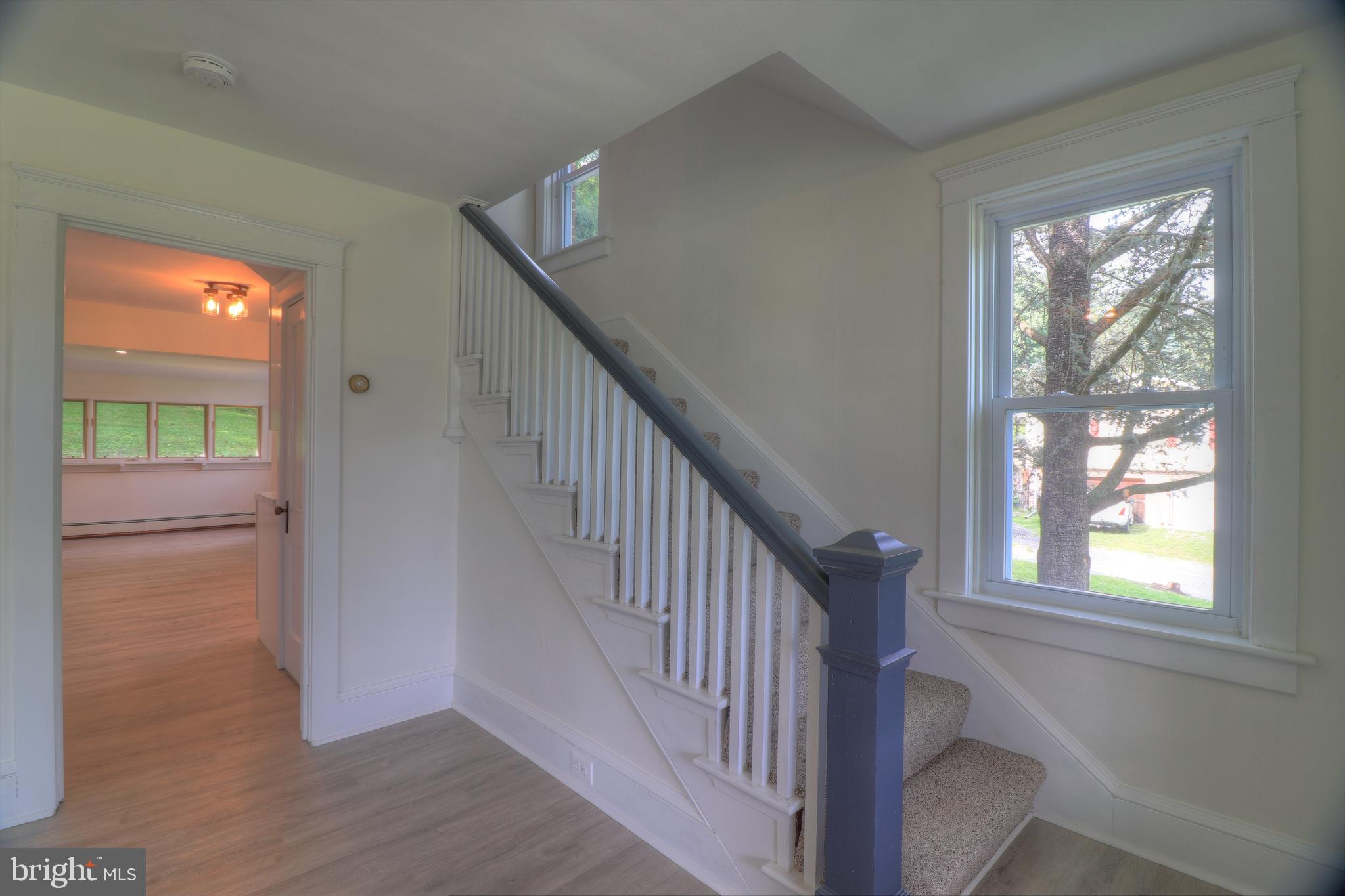 678 Rockville Road Spring Grove, PA 17362 - Photo 9 of 32 a view of an entryway with wooden floor leading to a furnished livingroom and windows