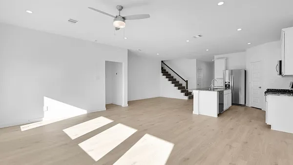 an empty room with a window and ceiling fan
