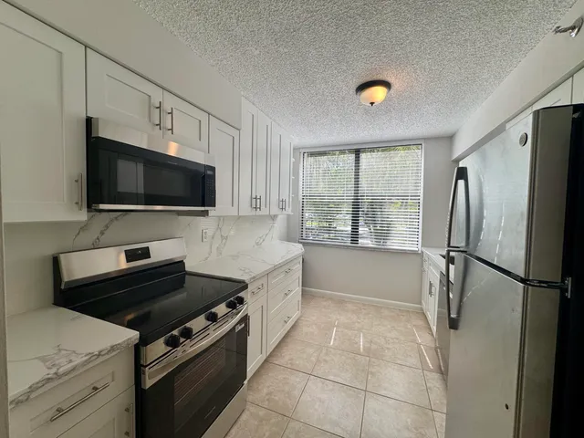 a kitchen with a stove a refrigerator and a sink