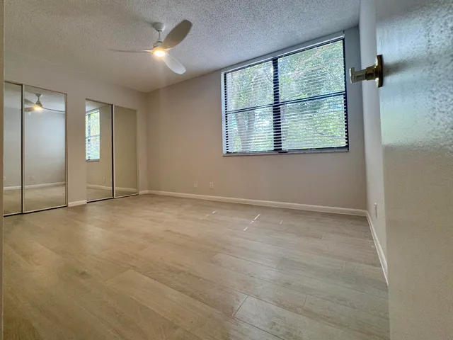 an empty room with windows and closet