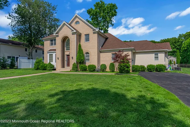 a front view of a house with a garden and trees