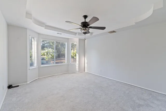 a view of a patio with table and chairs potted plants and floor to ceiling window