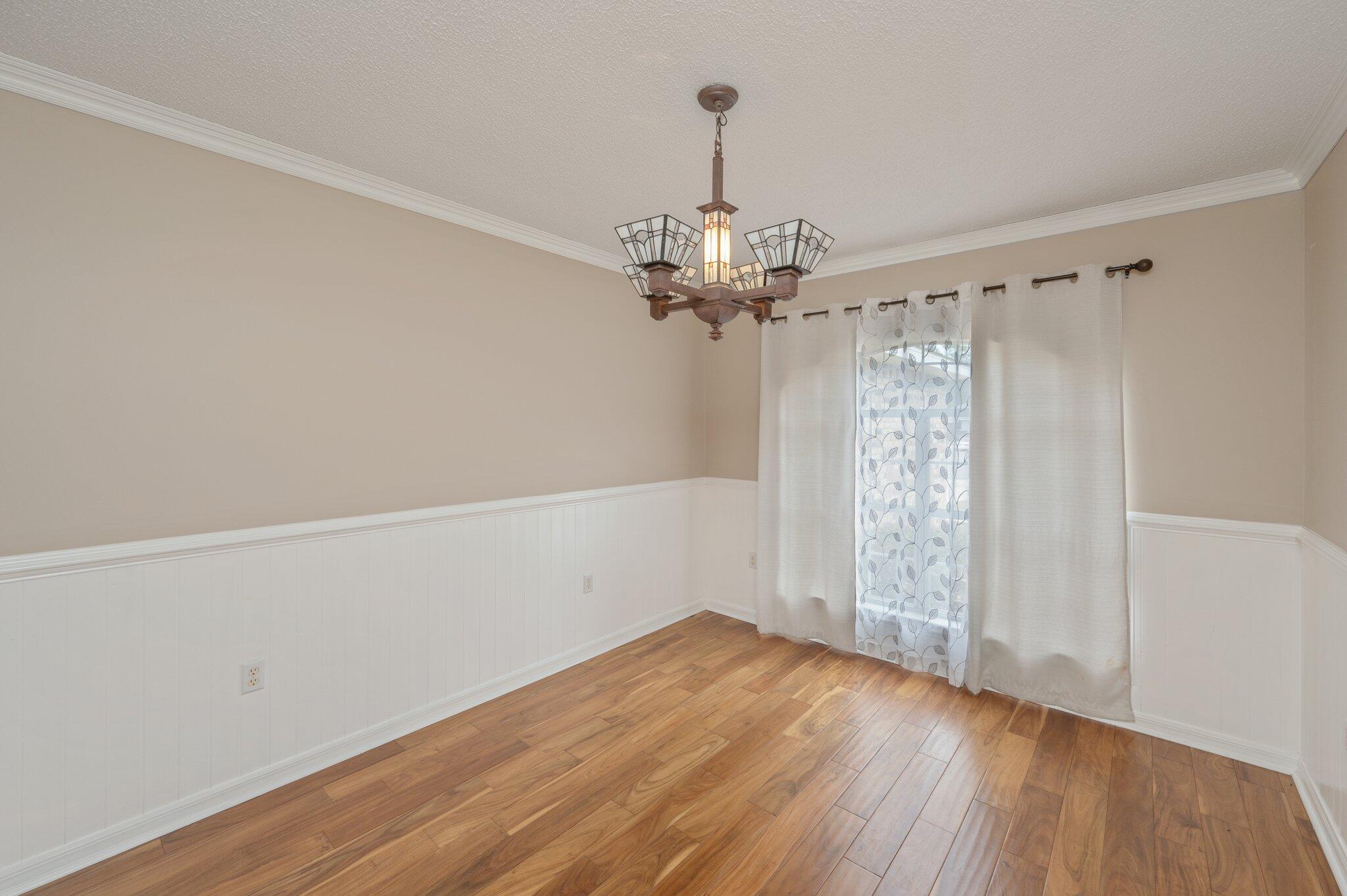 4752 Balboa Road Crestview, FL 32539 - Photo 16 of 46 a view of a room with wooden floor chandelier and window