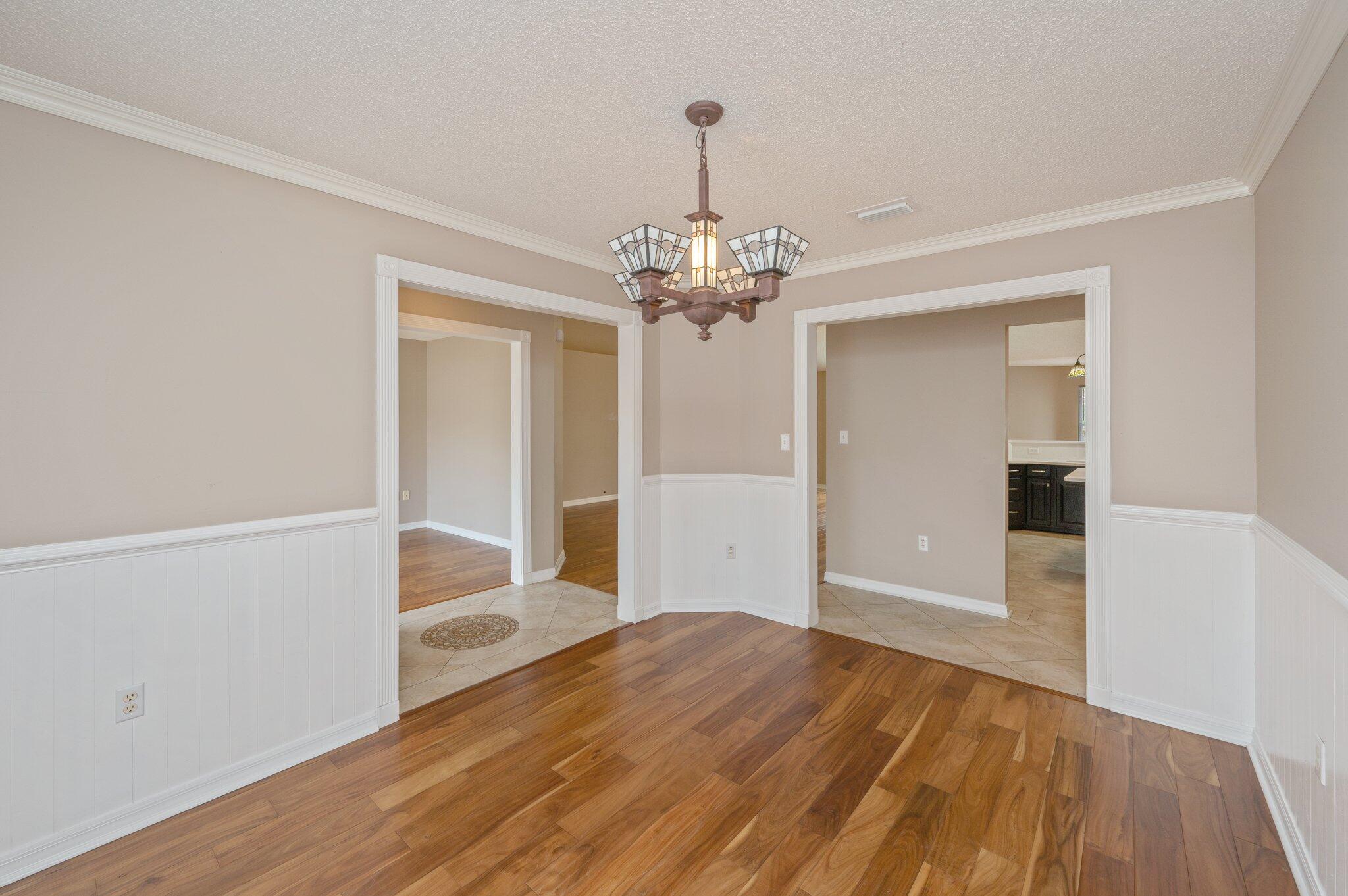 4752 Balboa Road Crestview, FL 32539 - Photo 17 of 46 a view of a hallway with wooden floor and a chandelier