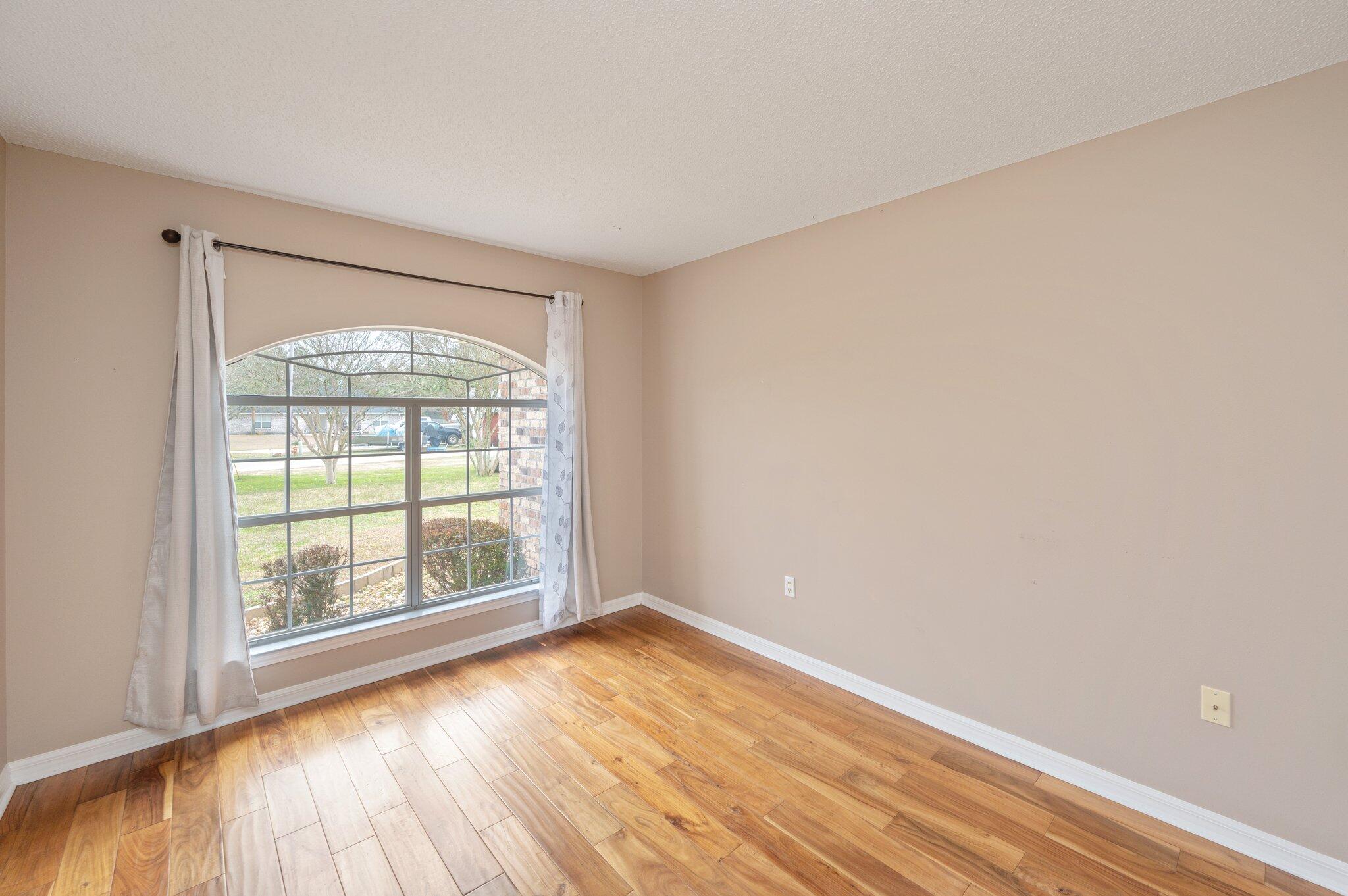 4752 Balboa Road Crestview, FL 32539 - Photo 18 of 46 an empty room with wooden floor and windows