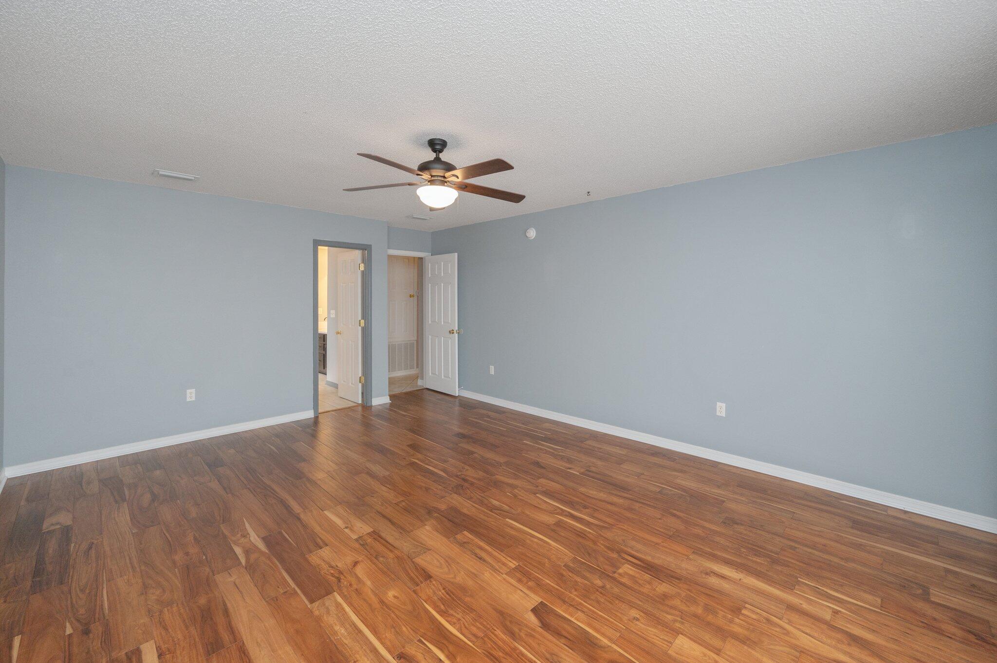 4752 Balboa Road Crestview, FL 32539 - Photo 22 of 46 a view of an empty room with wooden floor and a ceiling fan