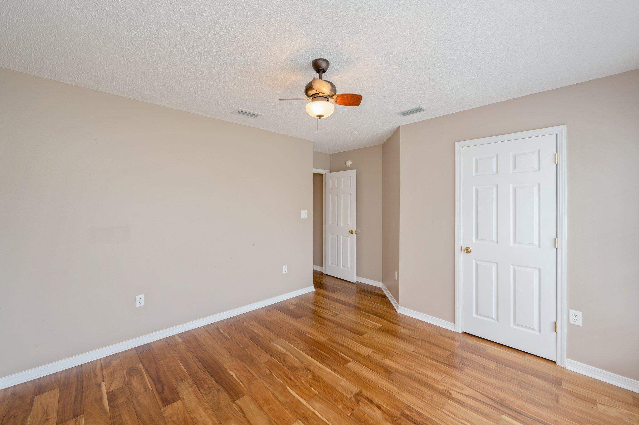 4752 Balboa Road Crestview, FL 32539 - Photo 30 of 46 a view of an empty room with wooden floor and a ceiling fan