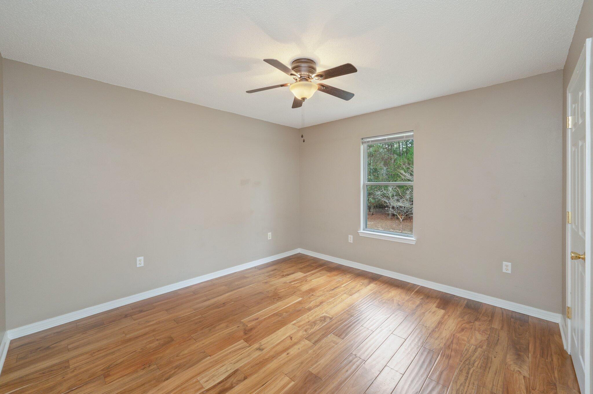 4752 Balboa Road Crestview, FL 32539 - Photo 33 of 46 wooden floor in an empty room with a window