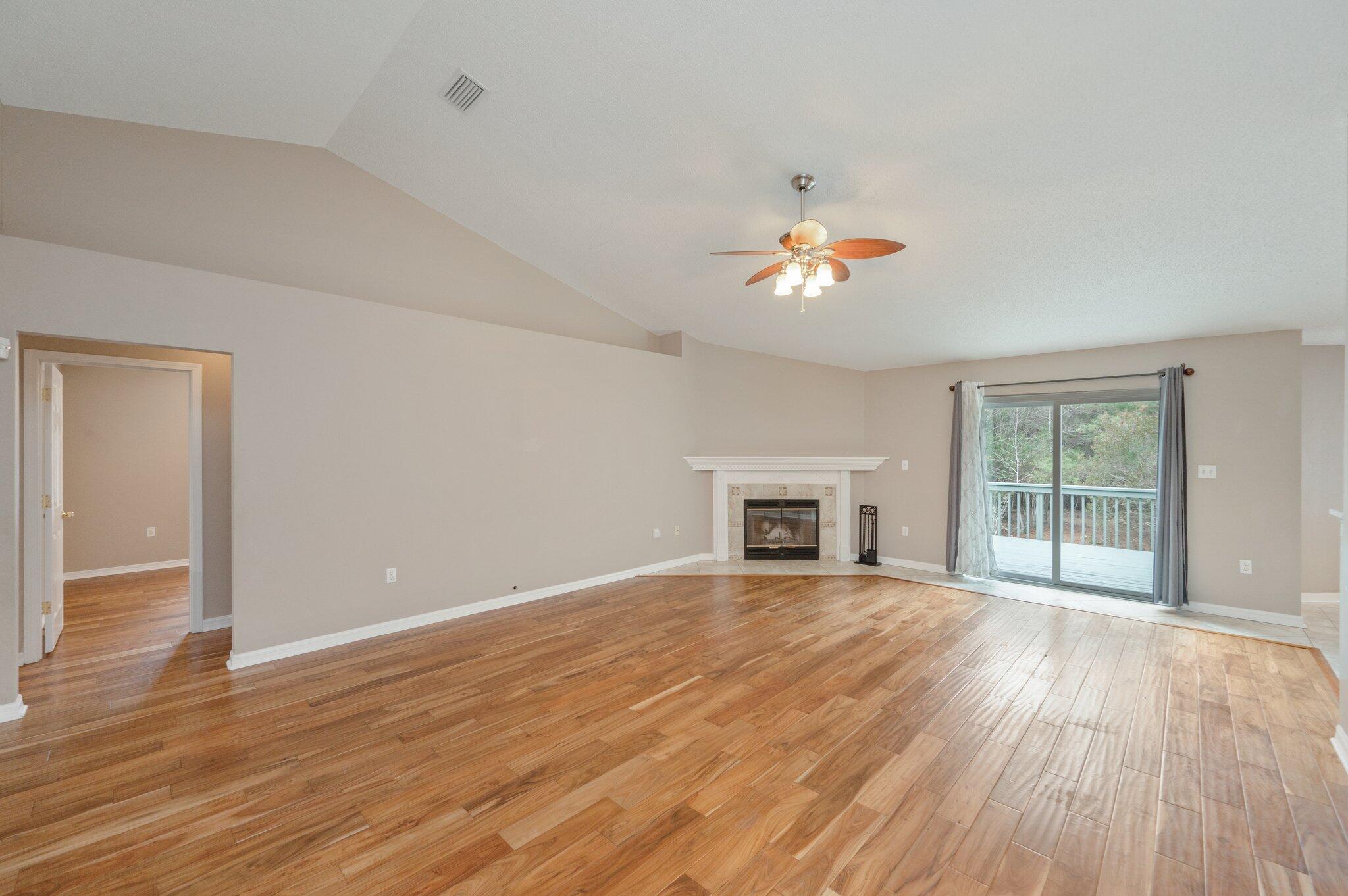 4752 Balboa Road Crestview, FL 32539 - Photo 6 of 46 wooden floor in an empty room with a fireplace