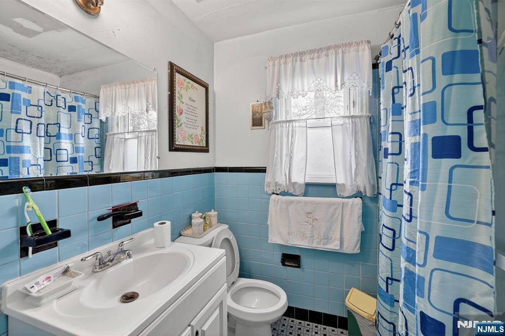 736 Vivian Terrace Union, NJ 07083 - Photo 13 of 16 a bathroom with a sink a toilet and a mirror