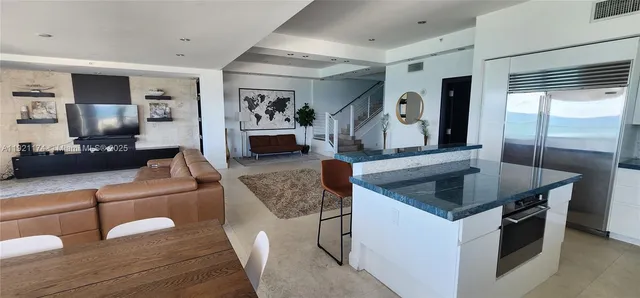 a kitchen with granite countertop a sink a counter top space and stainless steel appliances