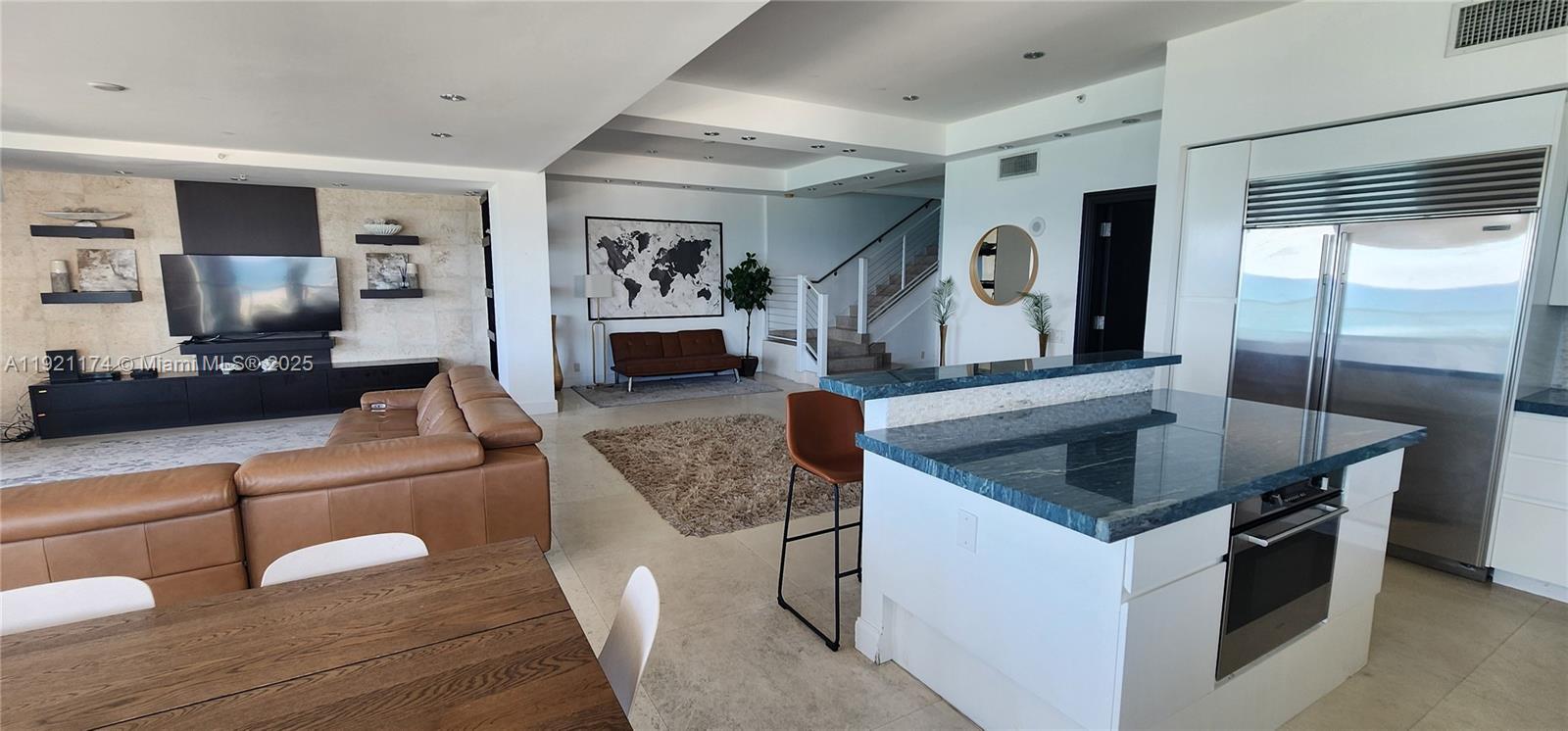 9499 Collins Avenue, Unit PH02 Surfside, FL 33154 - Photo 12 of 19 a kitchen with granite countertop a sink a counter top space and stainless steel appliances