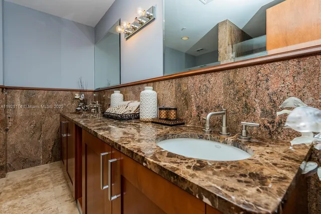 a bathroom with a granite countertop sink and a mirror