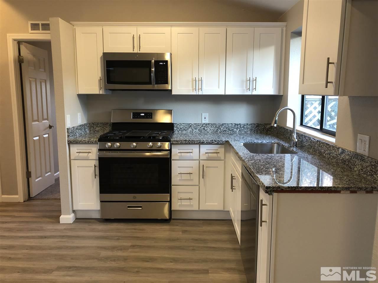 2631 Zinnia Avenue Reno, NV 89512 - Photo 6 of 15 a kitchen with granite countertop a sink and steel appliances