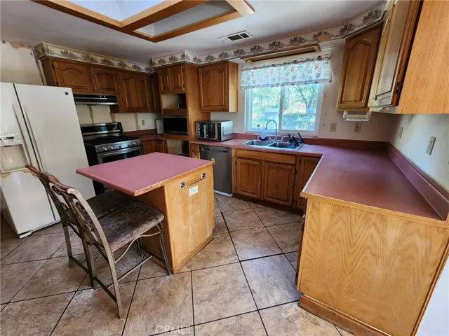 a kitchen with a stove a sink a refrigerator and a dining table