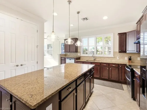 a kitchen with granite countertop a sink a center island and a window