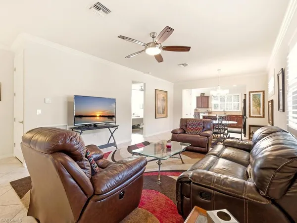 a living room with furniture a ceiling fan and a flat screen tv