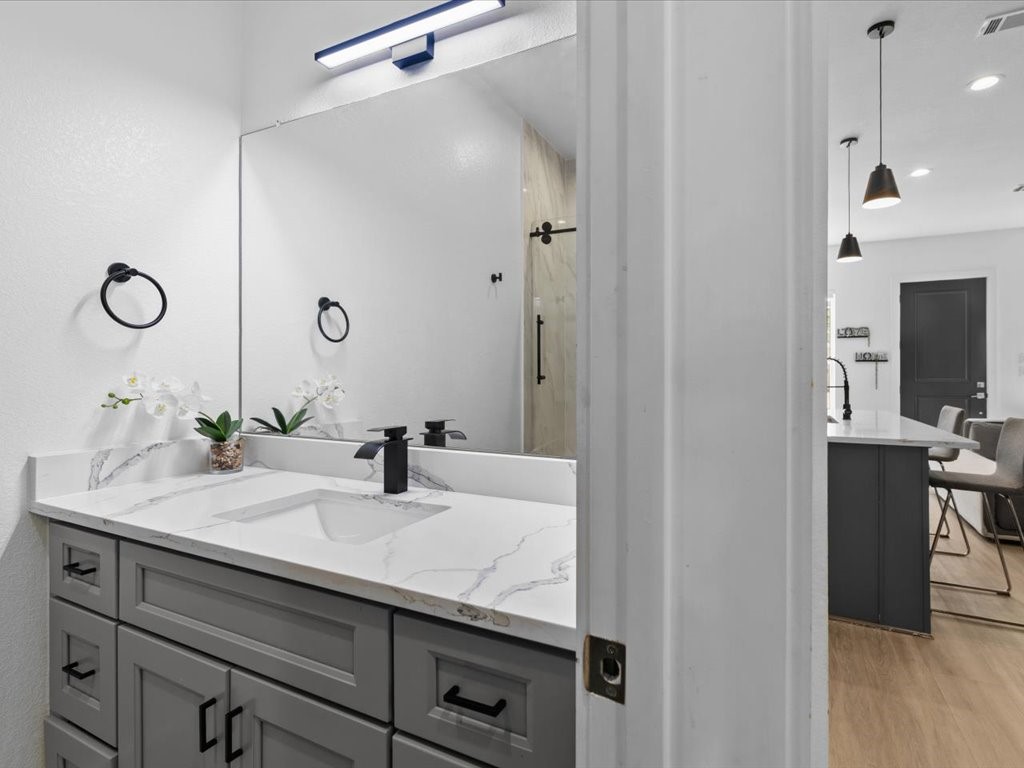 3549 Amos Street Houston, TX 77021 - Photo 12 of 25 a bathroom with a granite countertop sink a mirror and shower
