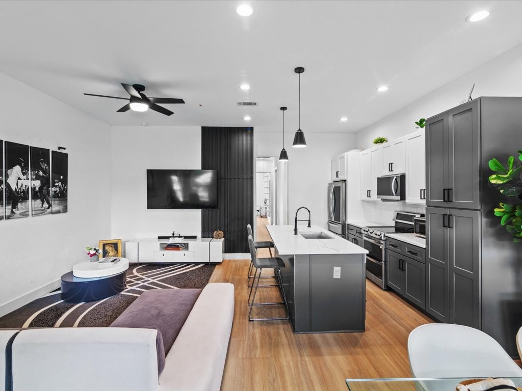 3549 Amos Street Houston, TX 77021 - Photo 15 of 25 a living room with stainless steel appliances furniture a flat screen tv and kitchen view