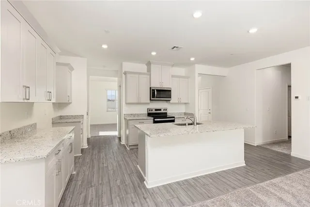 a large kitchen with stainless steel appliances kitchen island granite countertop a stove a sink and a refrigerator