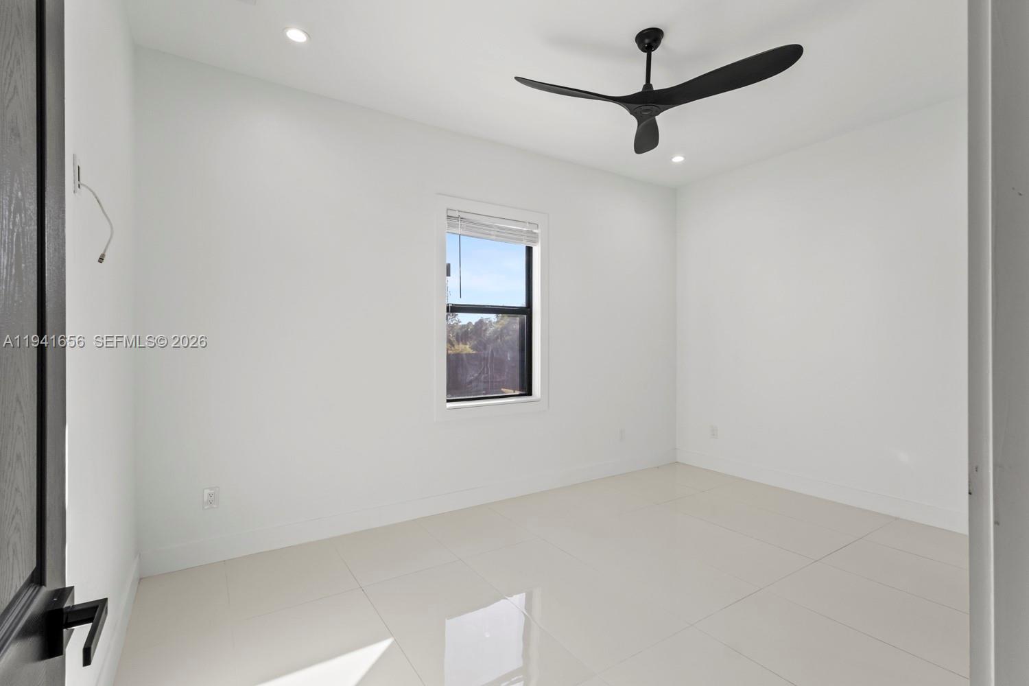 1236 East County Lehigh Acres, FL 33974 - Photo 14 of 44 an empty room with a ceiling fan and window