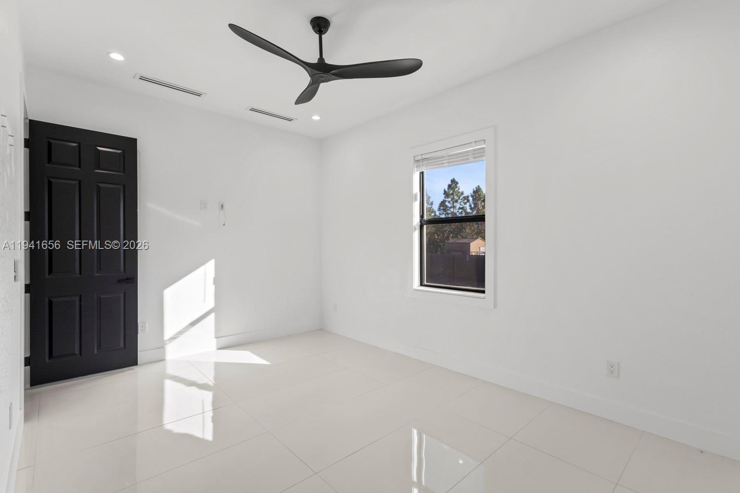 1236 East County Lehigh Acres, FL 33974 - Photo 15 of 44 en empty room with window and ceiling fan