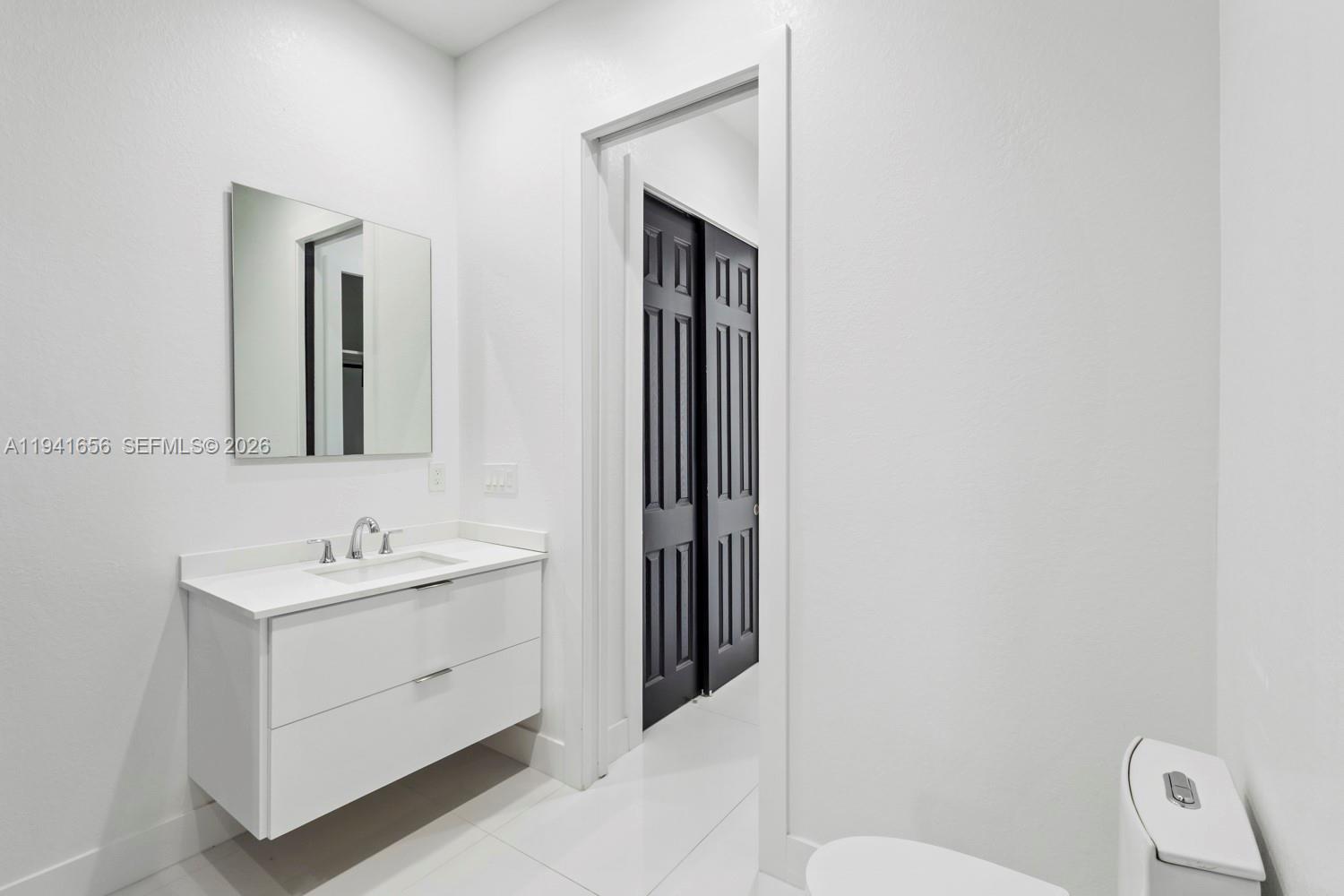 1236 East County Lehigh Acres, FL 33974 - Photo 17 of 44 a bathroom with a toilet sink and mirror