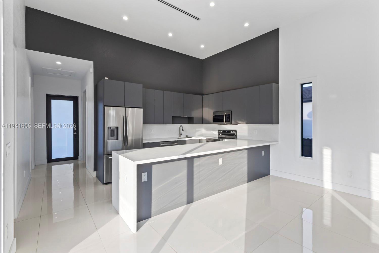 1236 East County Lehigh Acres, FL 33974 - Photo 6 of 44 a kitchen with a sink a refrigerator and cabinets