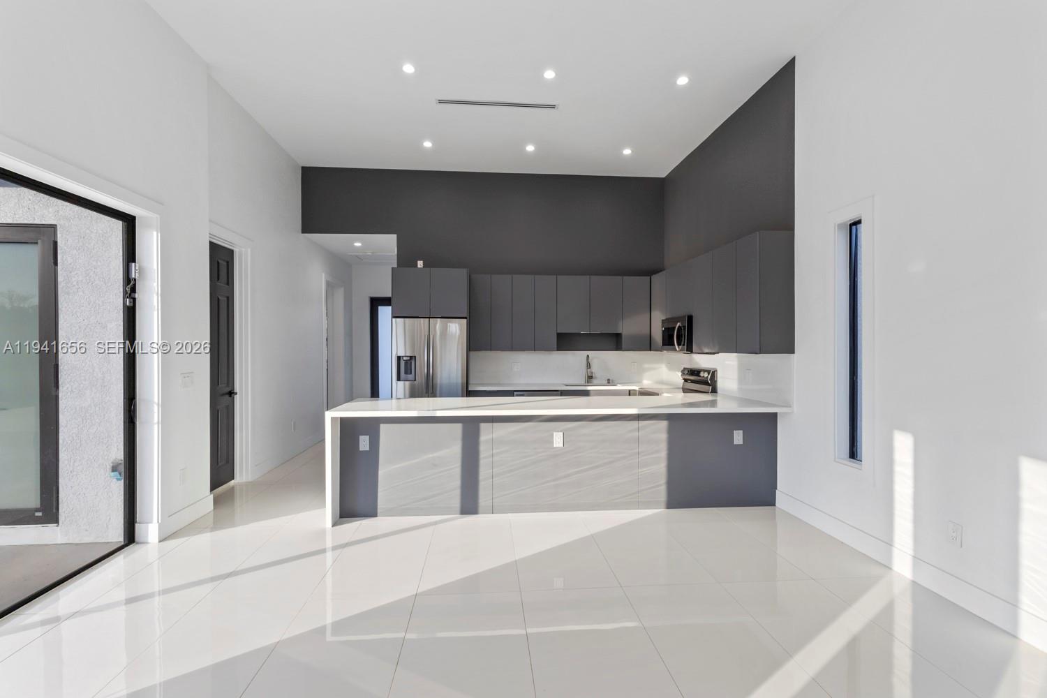 1236 East County Lehigh Acres, FL 33974 - Photo 7 of 44 a large white kitchen with a sink a refrigerator and a stove