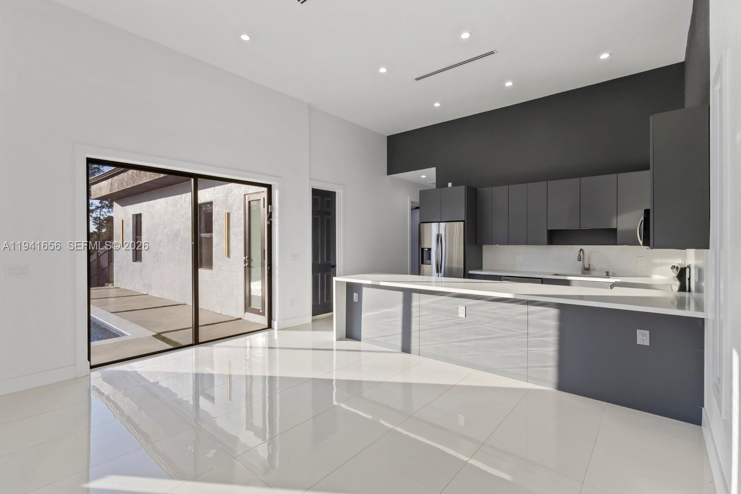 1236 East County Lehigh Acres, FL 33974 - Photo 8 of 44 a large kitchen with kitchen island a sink stainless steel appliances and cabinets