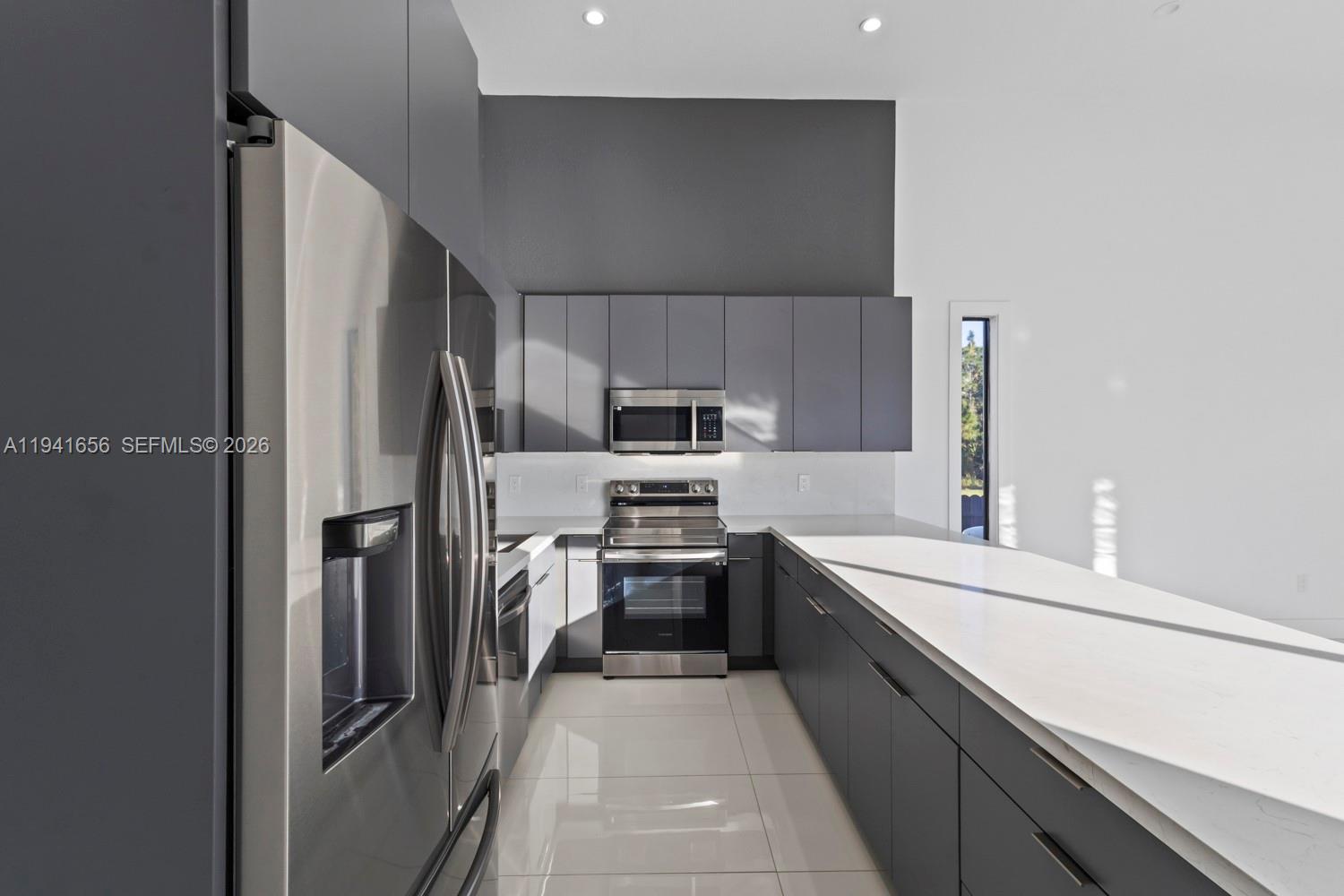 1236 East County Lehigh Acres, FL 33974 - Photo 9 of 44 a kitchen with stainless steel appliances a refrigerator sink and stove top oven