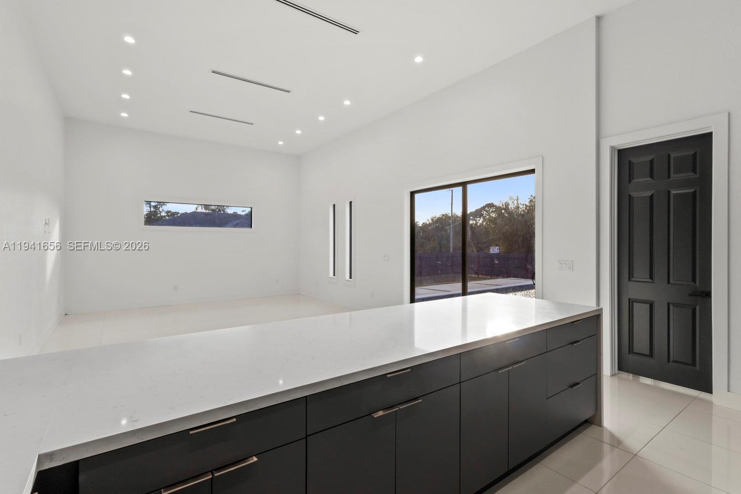 1236 East County Lehigh Acres, FL 33974 - Photo 10 of 44 a large white kitchen with a sink and large window