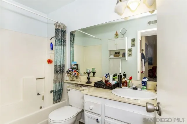 a bathroom with a sink vanity mirror and toilet