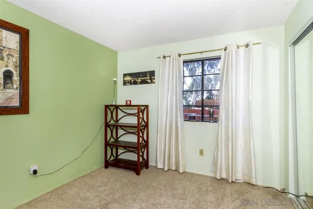 a view of an empty room with window and cabinet