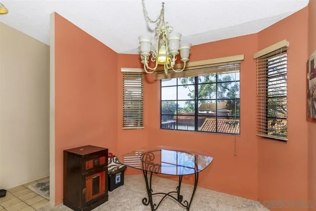 a room with chandelier fan and windows