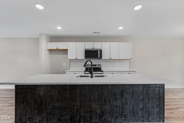 a kitchen with a sink stove and cabinets