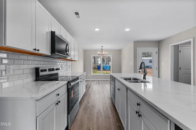 a kitchen with a sink microwave and cabinets