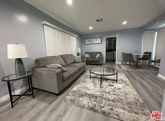 a living room with furniture and a wooden floor