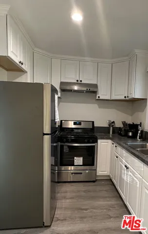 a kitchen with stainless steel appliances and white cabinets