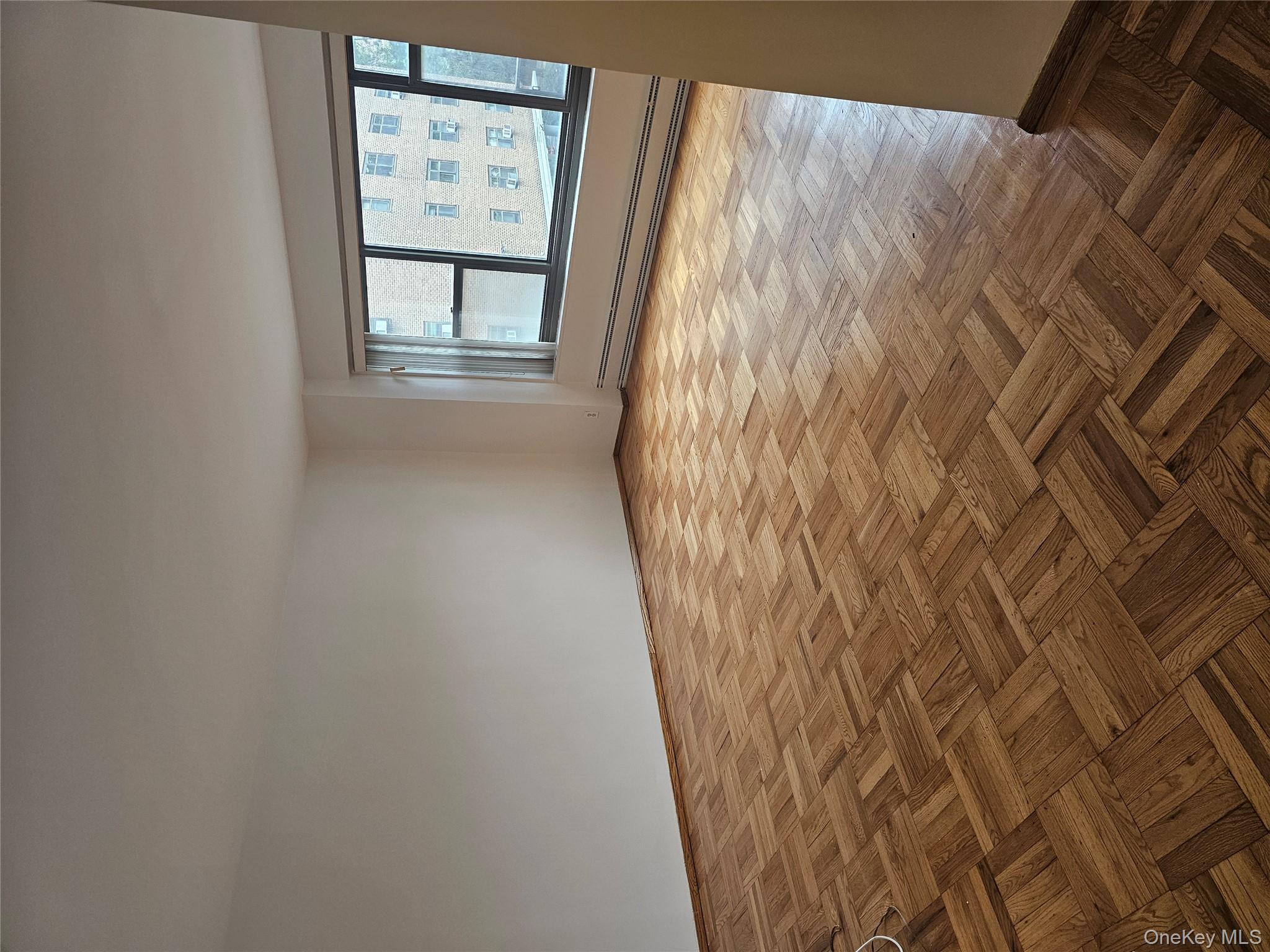 21-85 34th Avenue, Unit 3B Queens, NY 11106 - Photo 3 of 12 a view of an empty room with a window