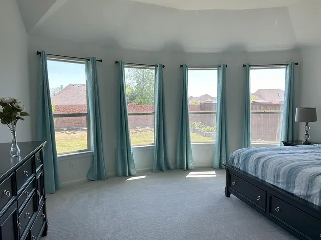 an empty room with a window and a ceiling fan