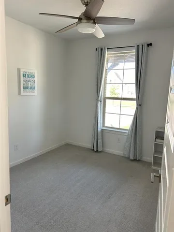 a bedroom with a bed and a lamp on the dresser