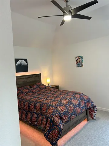 a bed sitting in a bedroom next to a window