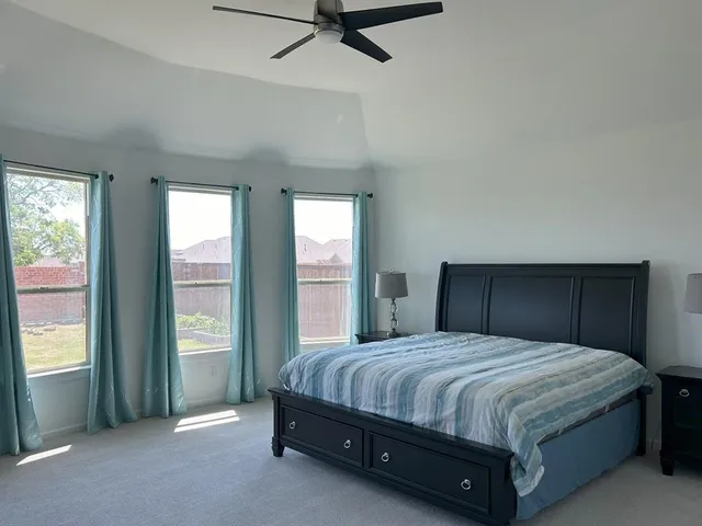 a spacious bedroom with a bed and a window