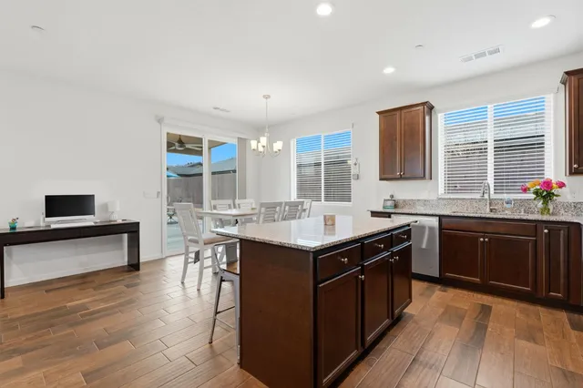 a kitchen with stainless steel appliances granite countertop a refrigerator a stove a sink and a microwave