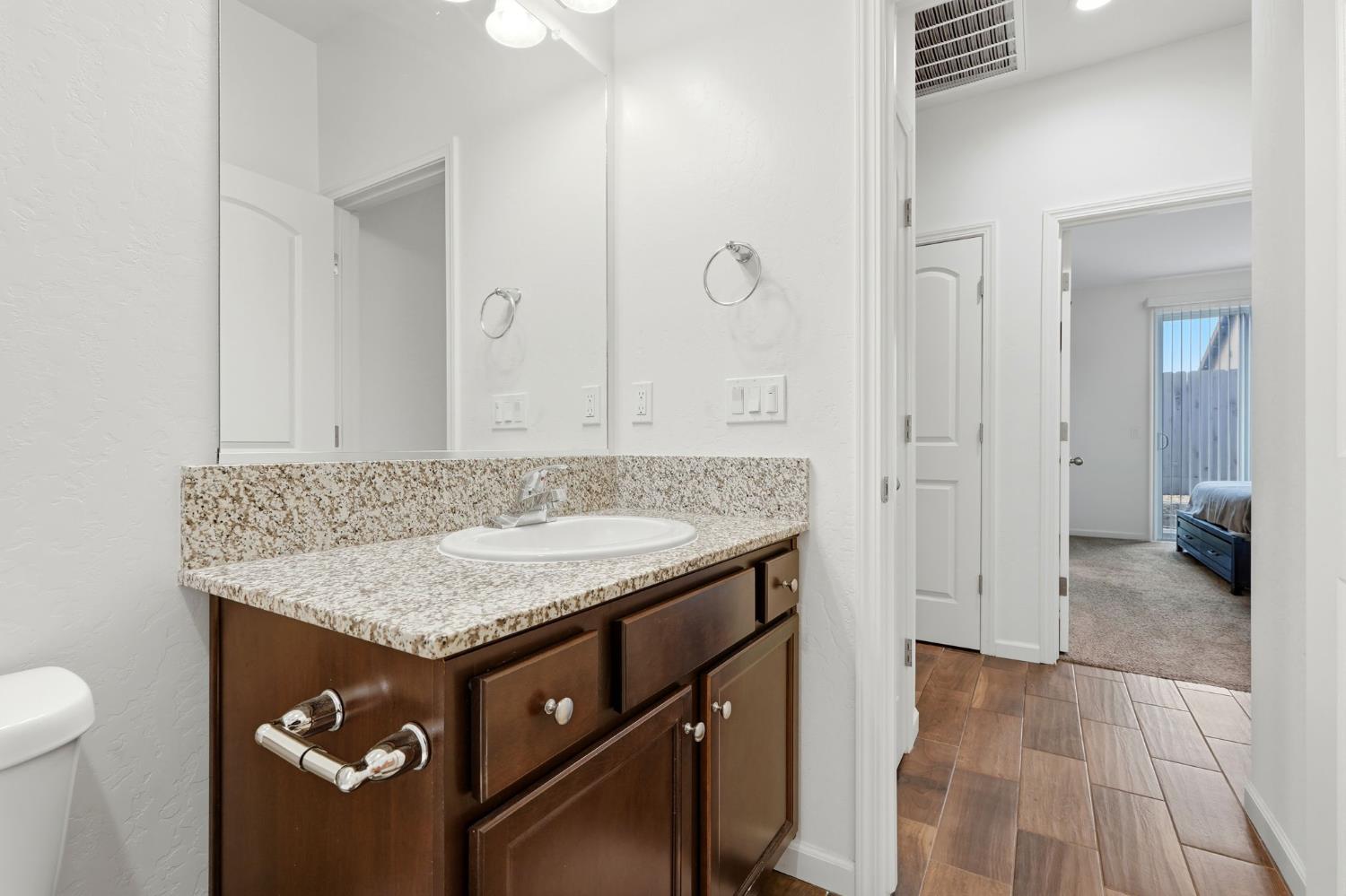 3125 Seymour Street Tulare, CA 93274 - Photo 39 of 52 a bathroom with a granite countertop sink a toilet and a shower