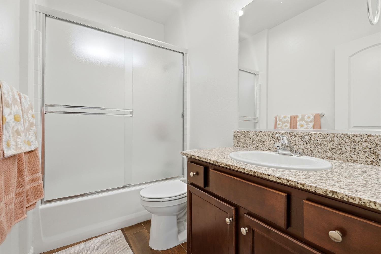 3125 Seymour Street Tulare, CA 93274 - Photo 40 of 52 a bathroom with a granite countertop sink toilet and shower
